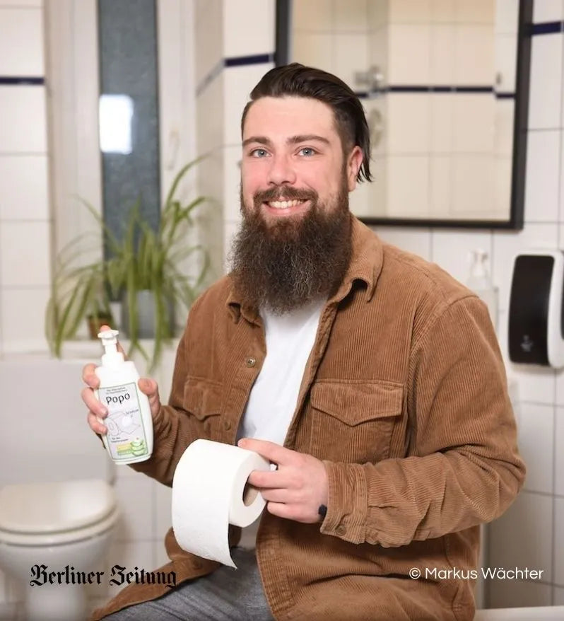 Der Gründer von PopoClean mit dem Produkt und einer Klopapierrolle